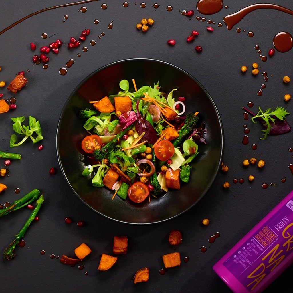 Ofen-Bowl mit Süßkartoffelwürfeln, Brokkoli, Kichererbsen, Mixsalat, Kirschtomaten, roten Zwiebeln, Granatapfelkernen, Parmesan und Fruity Granada Dressing